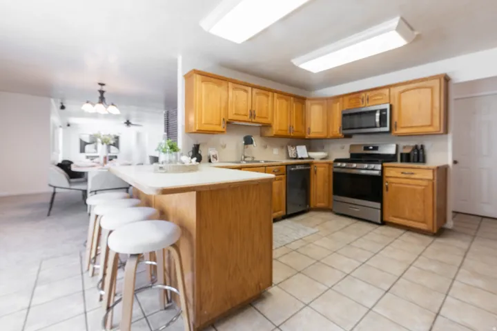 Kitchen featuring wood cabinetry, stainless steel appliances, and tiled flooring
