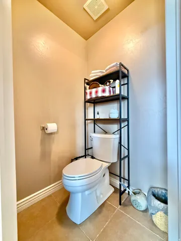 Recessed lighting, tile flooring, and a white toilet