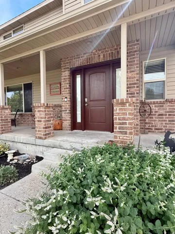 Covered porch with brick columns and siding exterior