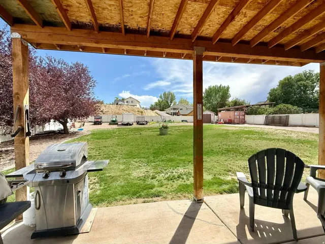 Covered patio with a concrete surface, exposed wood rafters, and wood support beams