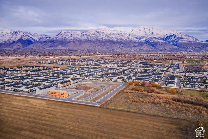 Expansive community with varied architectural styles, a developing residential area, and snow-capped mountain backdrop