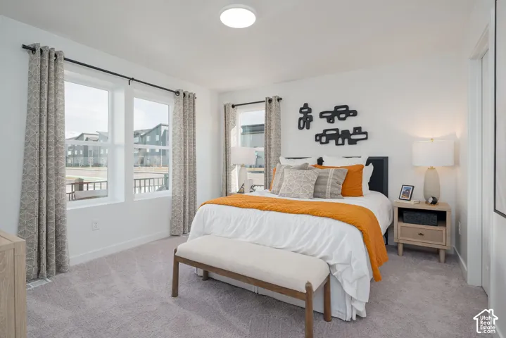 White walls with a flush-mount overhead light, and light gray carpet flooring