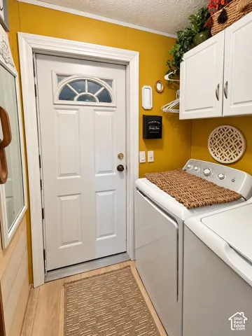 White paneled door with an arched transom, wood-finish flooring, and crisp white cabinetry