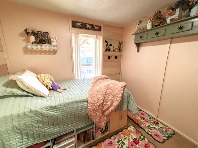 Wood-finish flooring with light-colored walls and a window featuring white trim