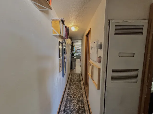 Hallway with wood-finish flooring and an overhead light fixture