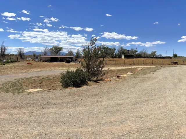 Gravel driveway and land with distant mountains and a blue sky