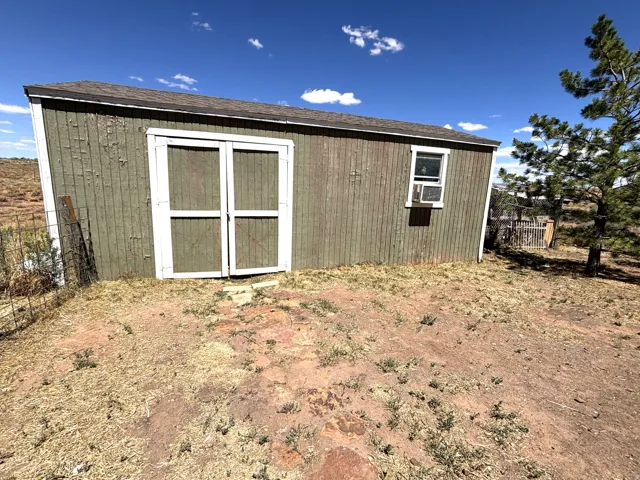 Wood-sided outbuilding with white trim detailing