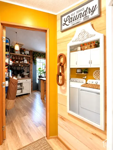 Built-in laundry station featuring upper cabinetry and a full-size washer and dryer