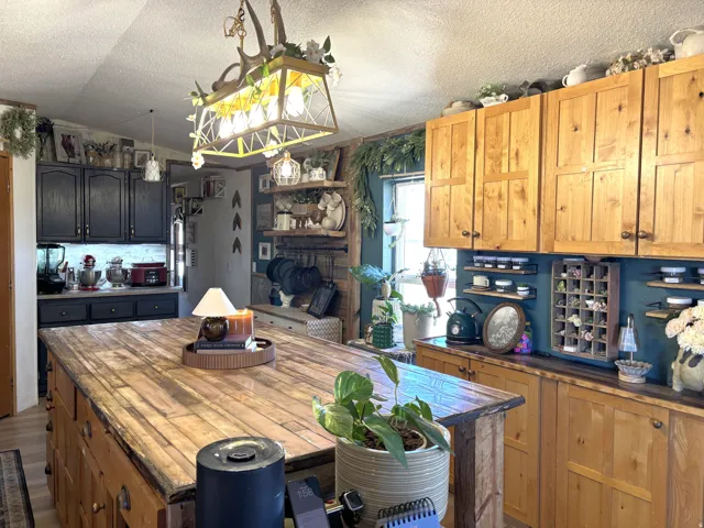 Large wood-finish kitchen island with integrated storage, featuring a unique antler-inspired chandelier