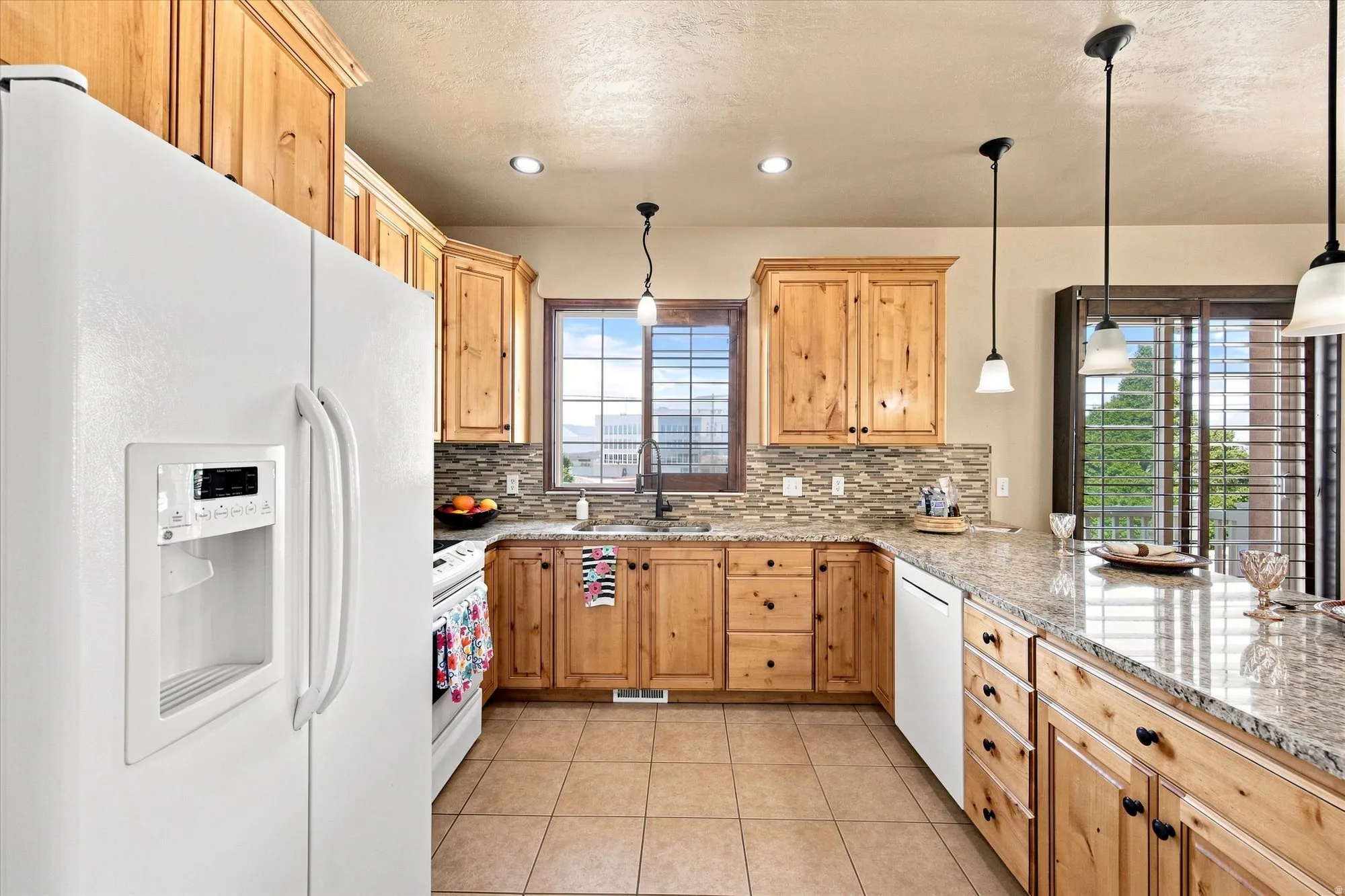 Kitchen featuring wood cabinetry, granite countertops, a tiled backsplash, and recessed lighting
