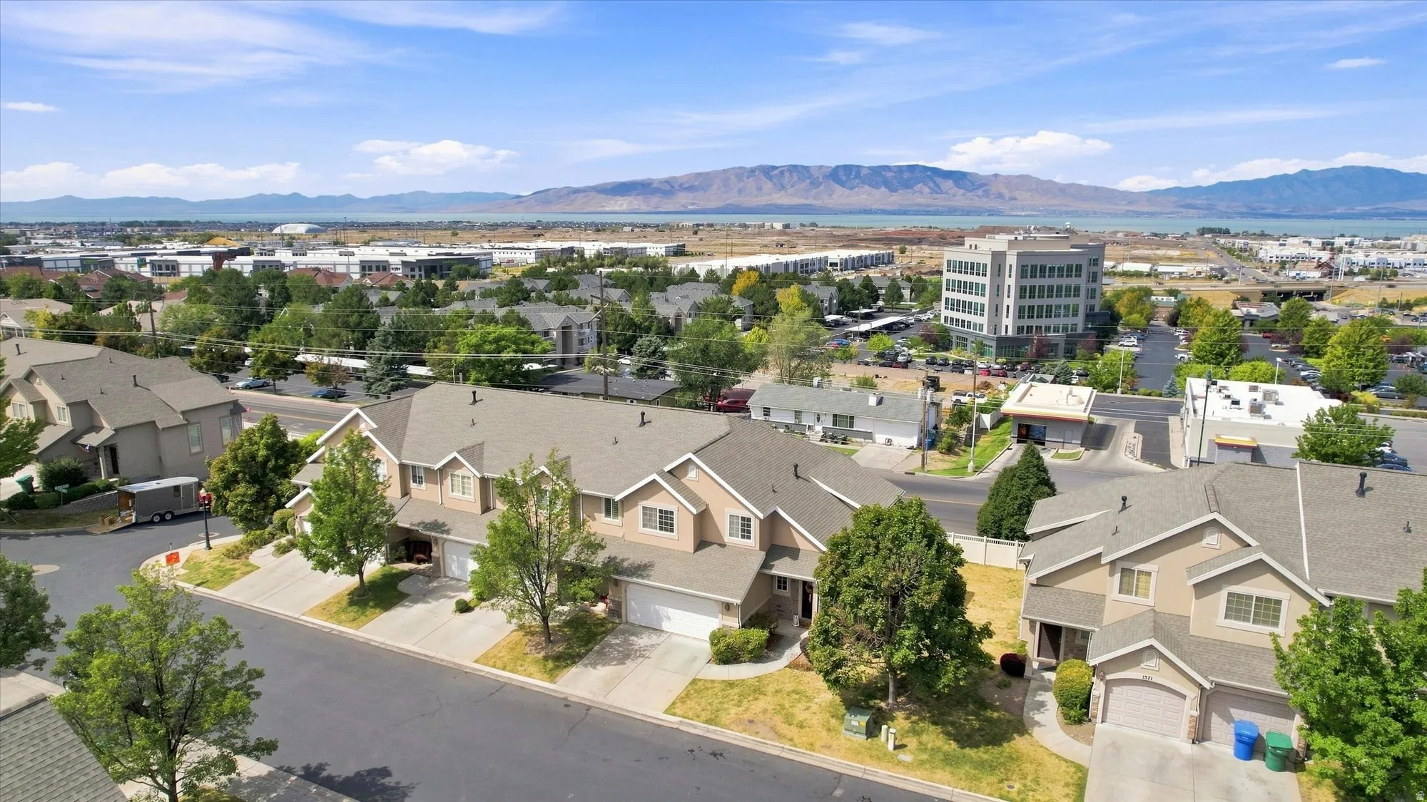 Townhome community with attached garages, mature landscaping, and mountain scenery