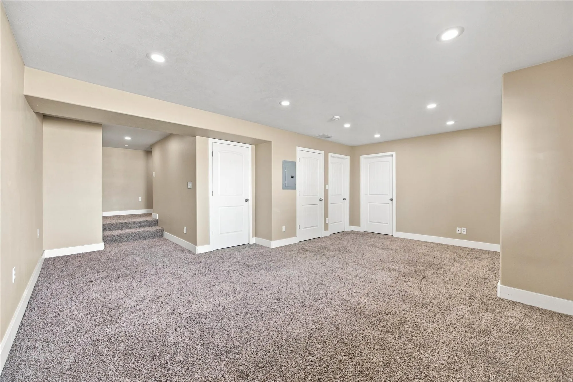 Spacious room featuring neutral paint, recessed lighting, white interior doors, and plush carpeting