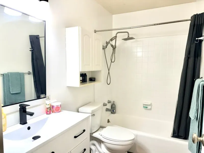 White vanity with black hardware and an integrated sink
