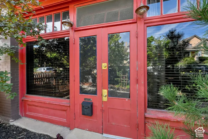 Dual entry doors with full-length glass panels, transom windows, and exterior wall sconces