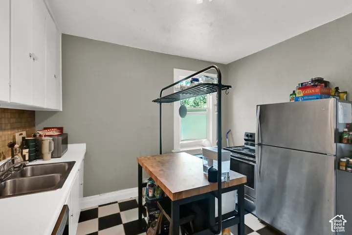 White cabinetry, stainless steel appliances, and a tile backsplash
