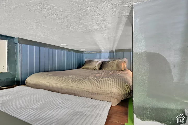 Recessed lighting illuminates the space, featuring blue wainscoting paneling and wood-finish flooring