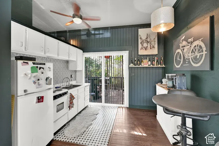 Kitchen featuring white cabinetry, a built-in range, a stainless steel sink, and wood-finish flooring