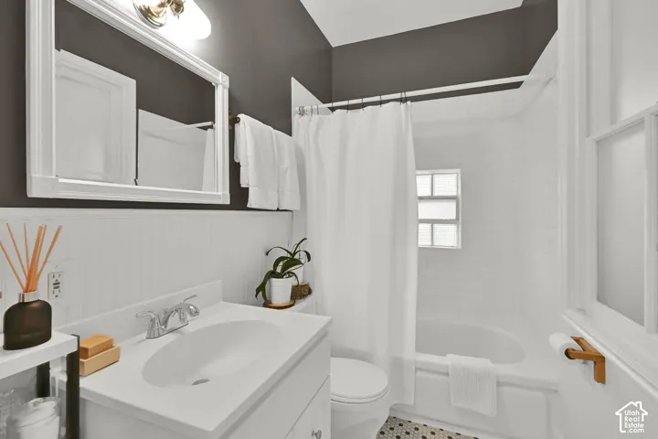 White vanity with integrated sink, chrome faucet, and white beadboard wainscoting
