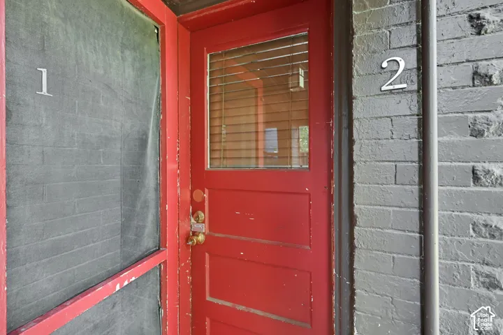 Red painted entry door with glass panel and blinds