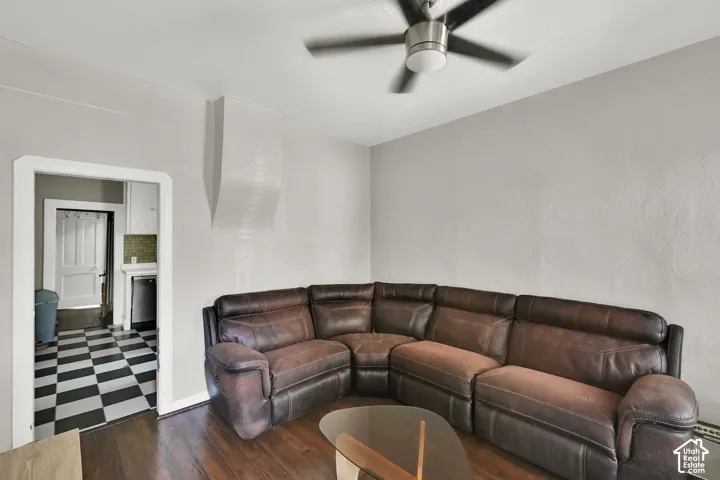 Wood-finish flooring, ceiling fan with brushed nickel accents, and a wide entryway