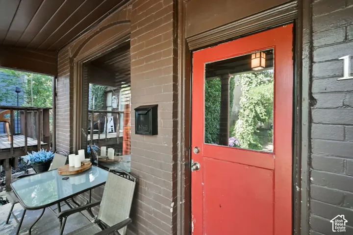 Brick exterior with a vibrant red entry door featuring a glass panel