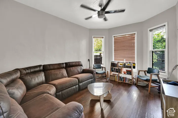 Spacious interior with dark wood-finish flooring, multiple windows, and a ceiling fan