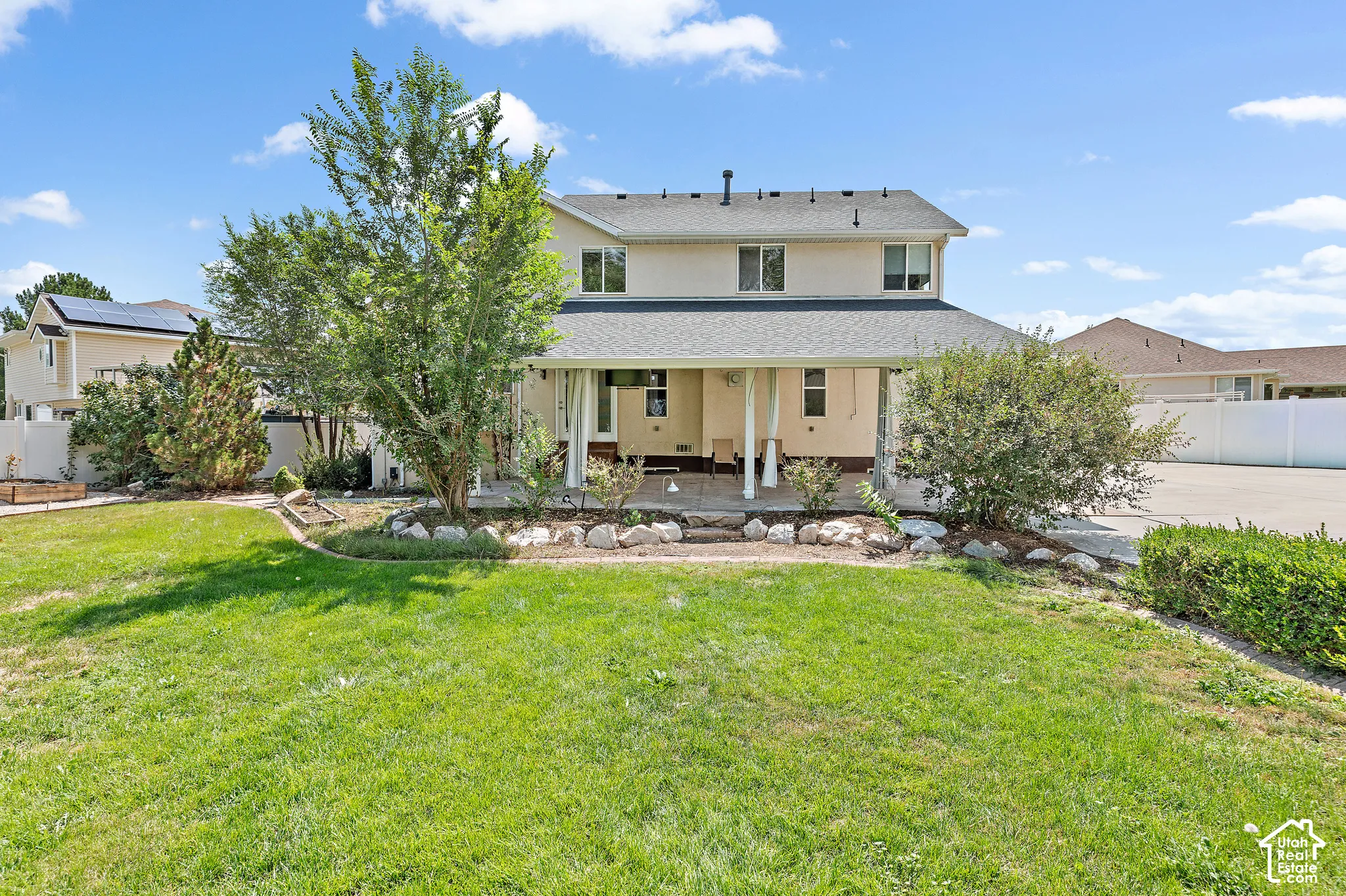 Expansive green lawn with mature trees and established landscaping