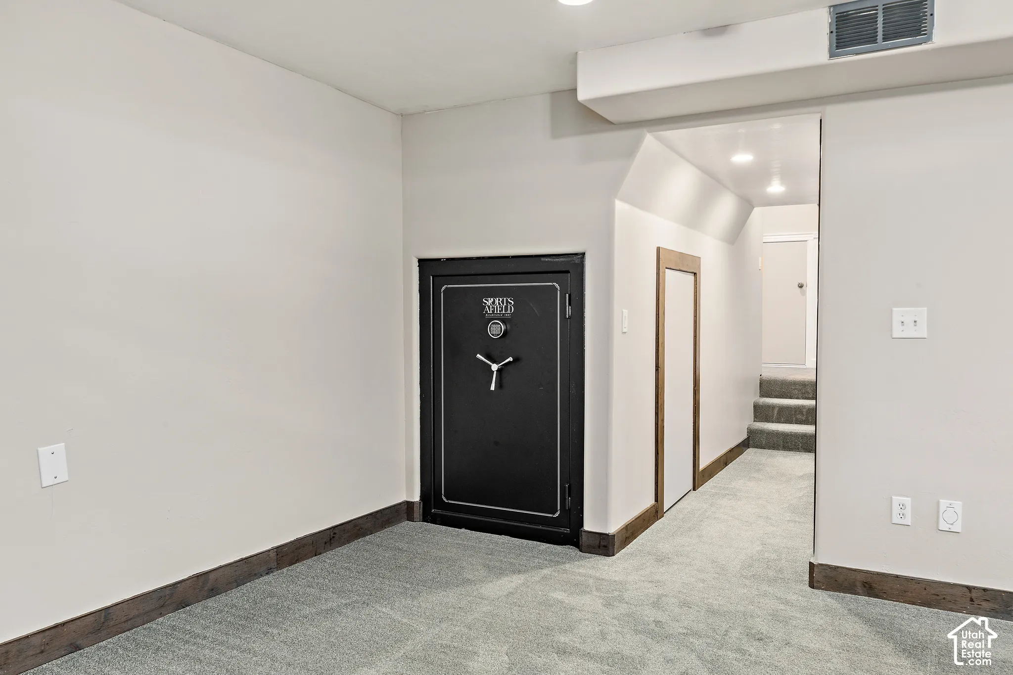 Built-in heavy-duty steel vault door, recessed lighting, wall-to-wall carpet, and stained wood trim
