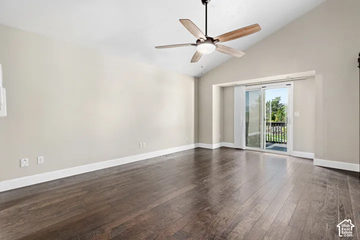 Primary bedroom, vaulted ceilings with a ceiling fan, hardwood flooring, and sliding glass doors leading to a balcony