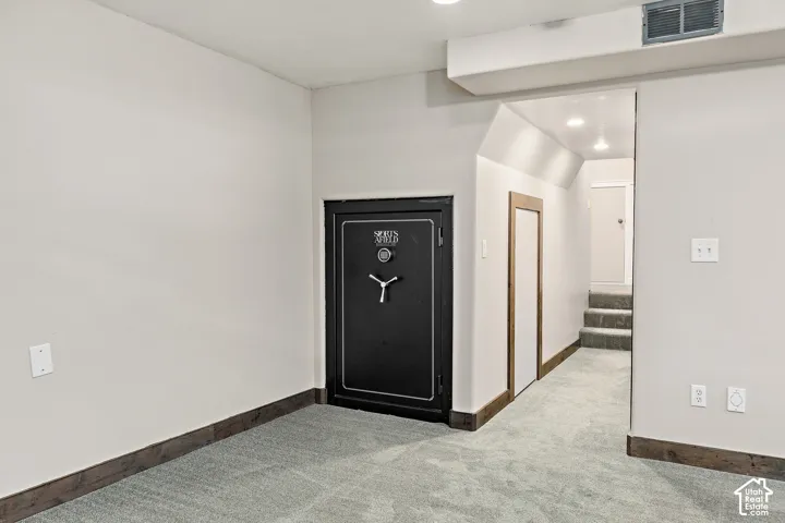 Built-in heavy-duty steel vault door, recessed lighting, wall-to-wall carpet, and stained wood trim