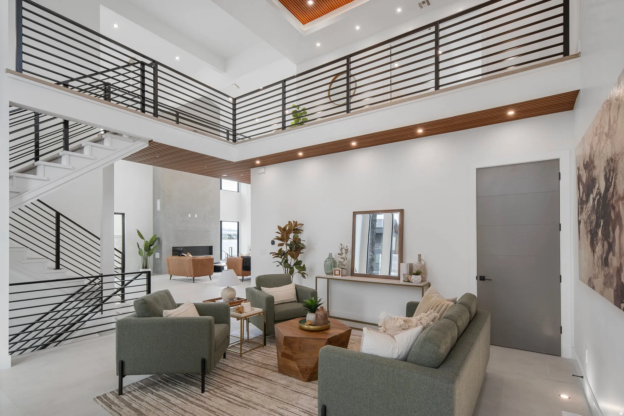 Two-story living area with high ceilings, recessed lighting, and a modern fireplace