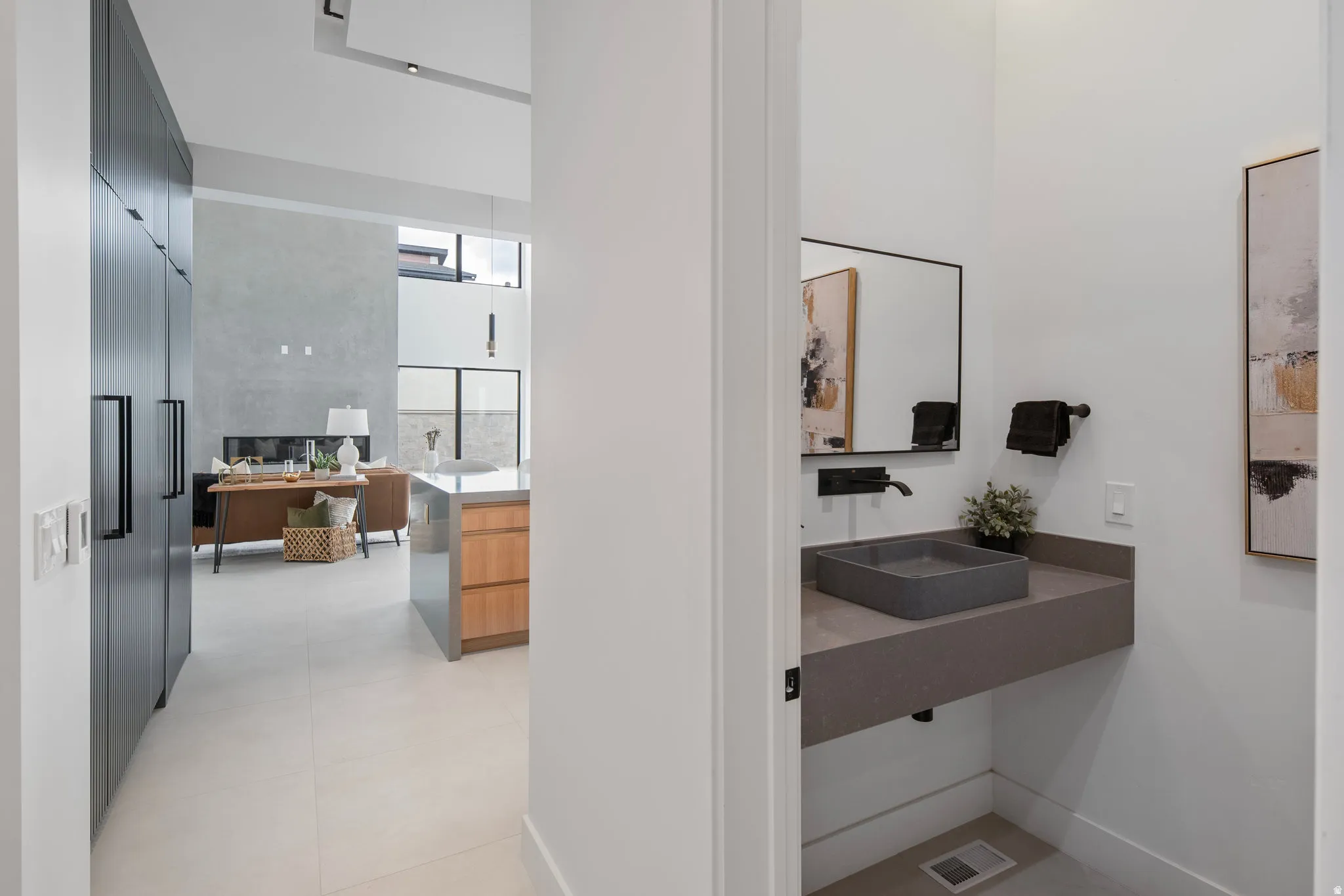 Floating vanity with rectangular vessel sink, wall-mounted faucet, and integrated towel bar