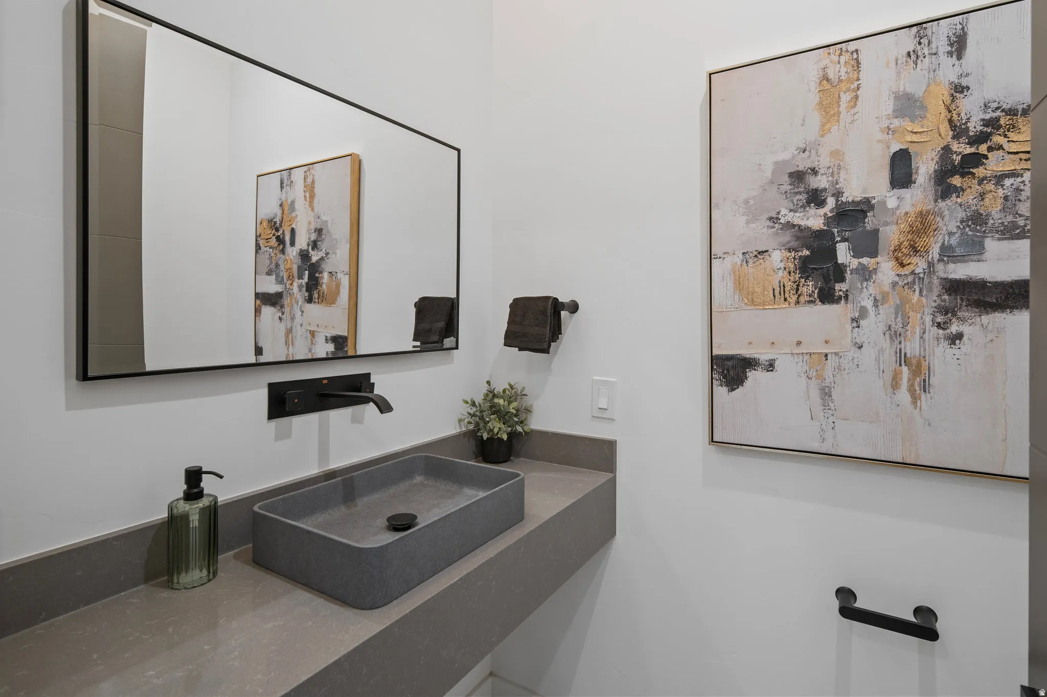 Floating vanity with a rectangular vessel sink, wall-mounted faucet, and matte black accents