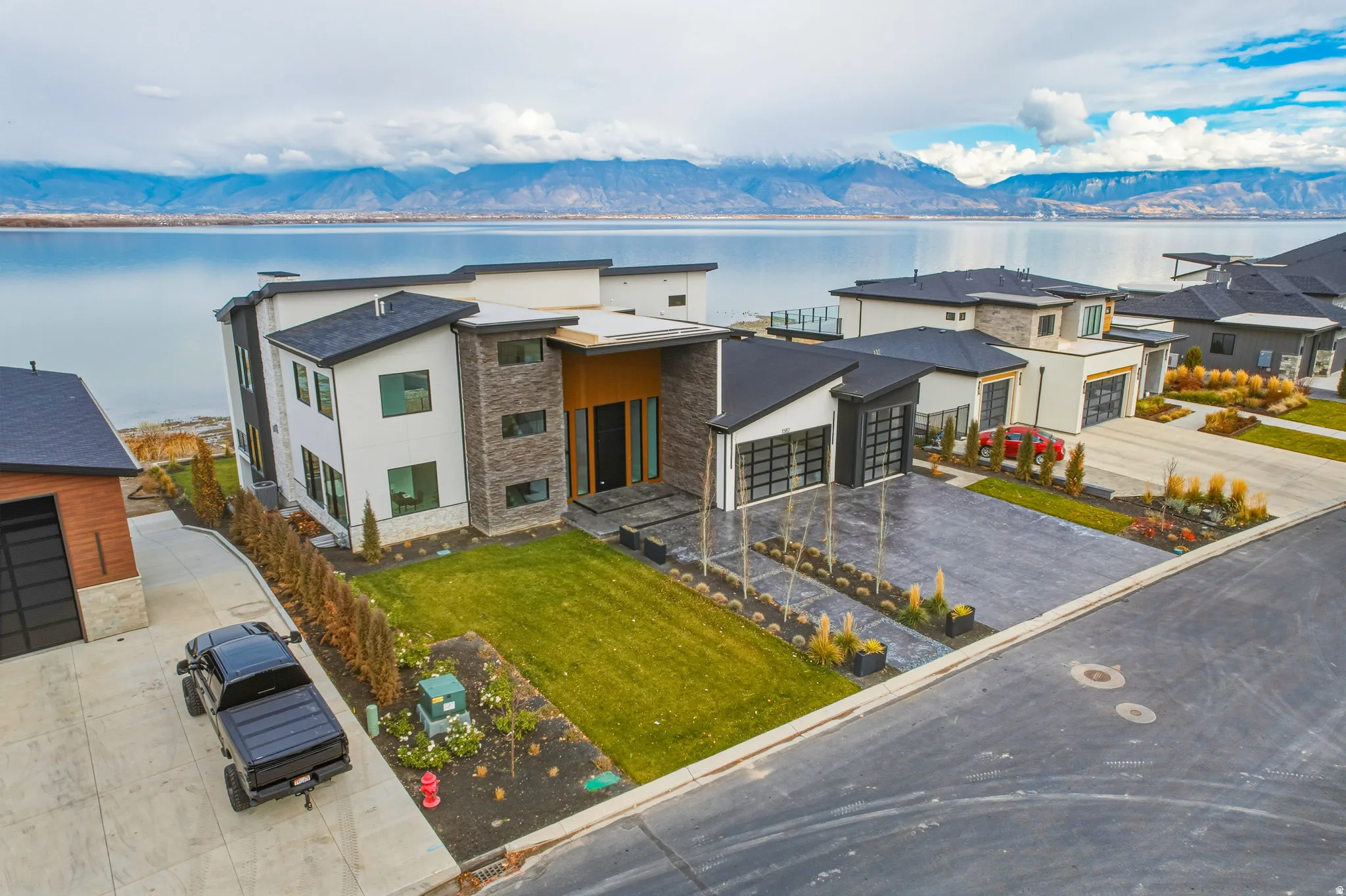 Contemporary residence featuring a multi-level design with stone and stucco exterior finishes, large windows, and an attached two-car garage