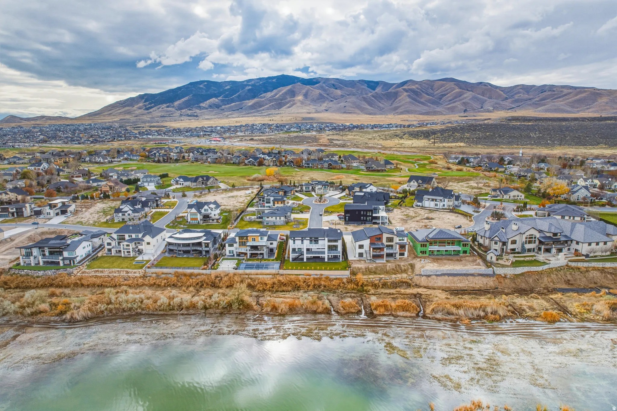 Expansive neighborhood featuring a water body, mountainous backdrop, and residential properties