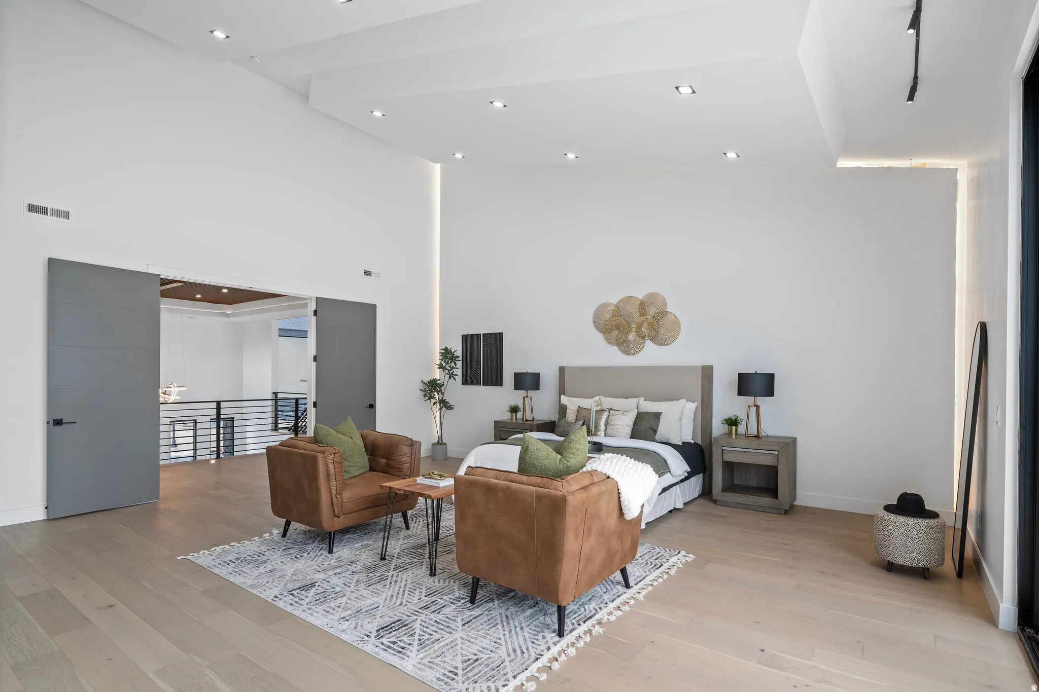 Vaulted ceilings with recessed lighting, light wood-finish flooring, and large sliding doors