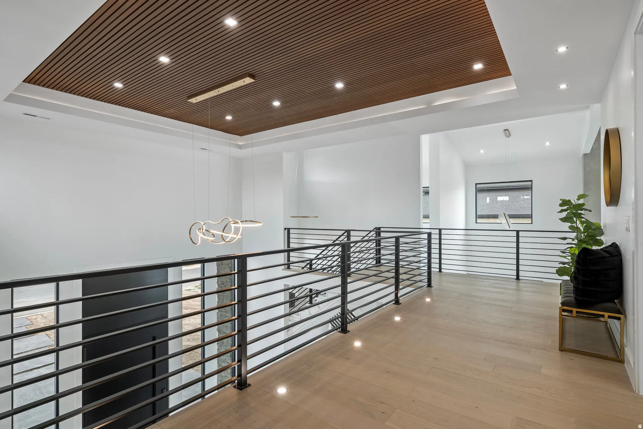 Wood-finish ceiling detail, recessed lighting, and contemporary pendant fixtures