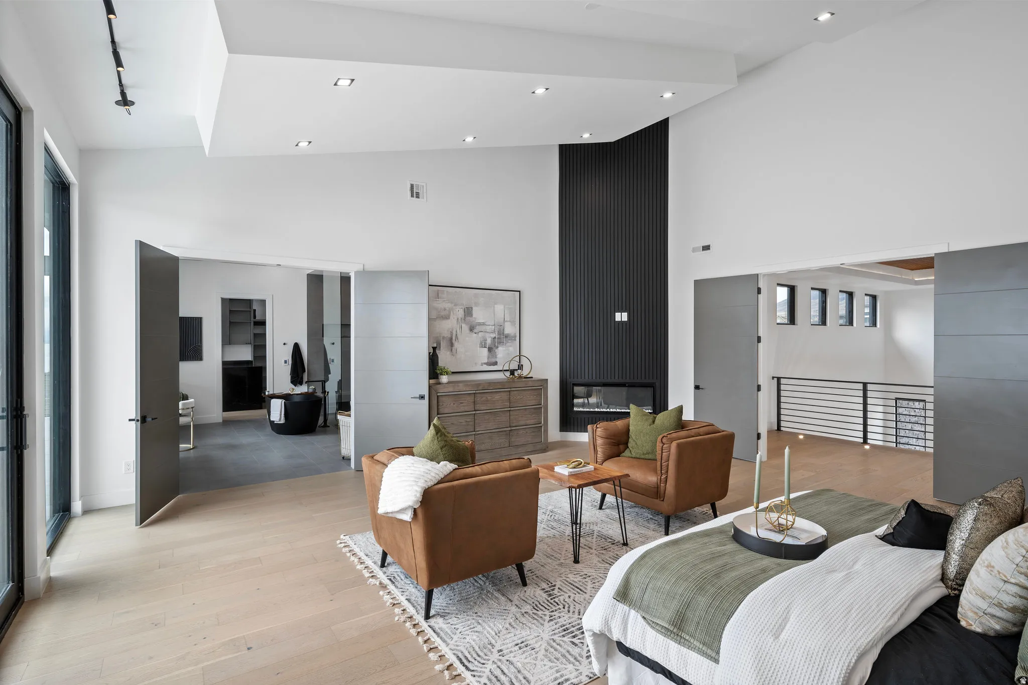 High ceilings with recessed lighting, wood-finish flooring, a built-in fireplace, and sliding panel doors