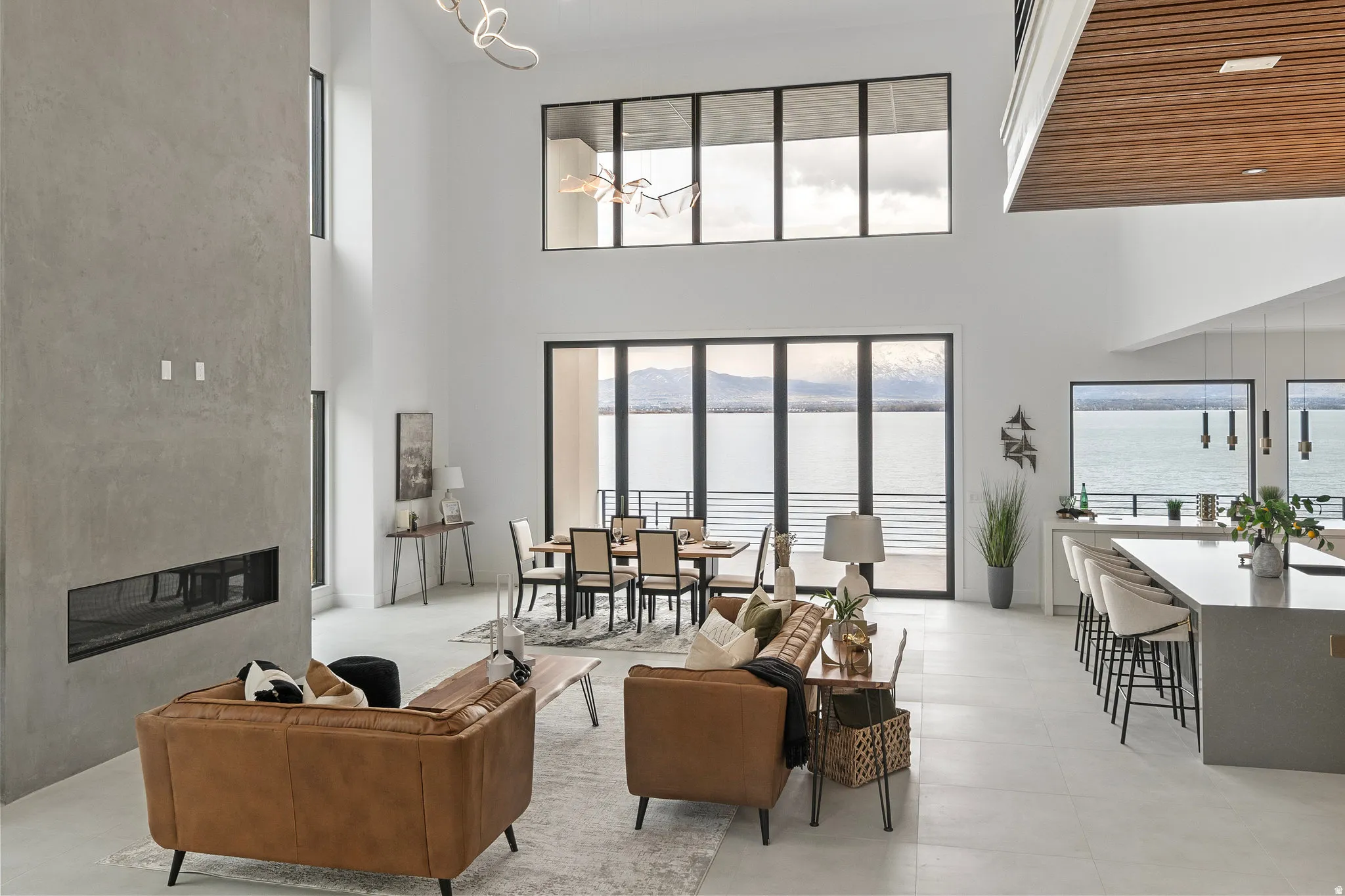 Expansive great room with soaring ceilings, a linear fireplace, and floor-to-ceiling windows