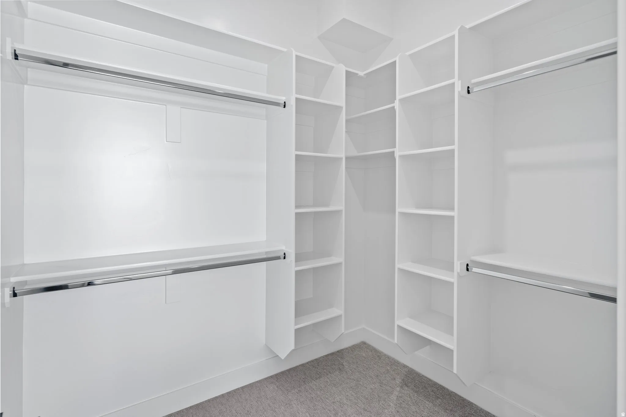 Built-in closet system featuring white shelving and chrome hanging rods