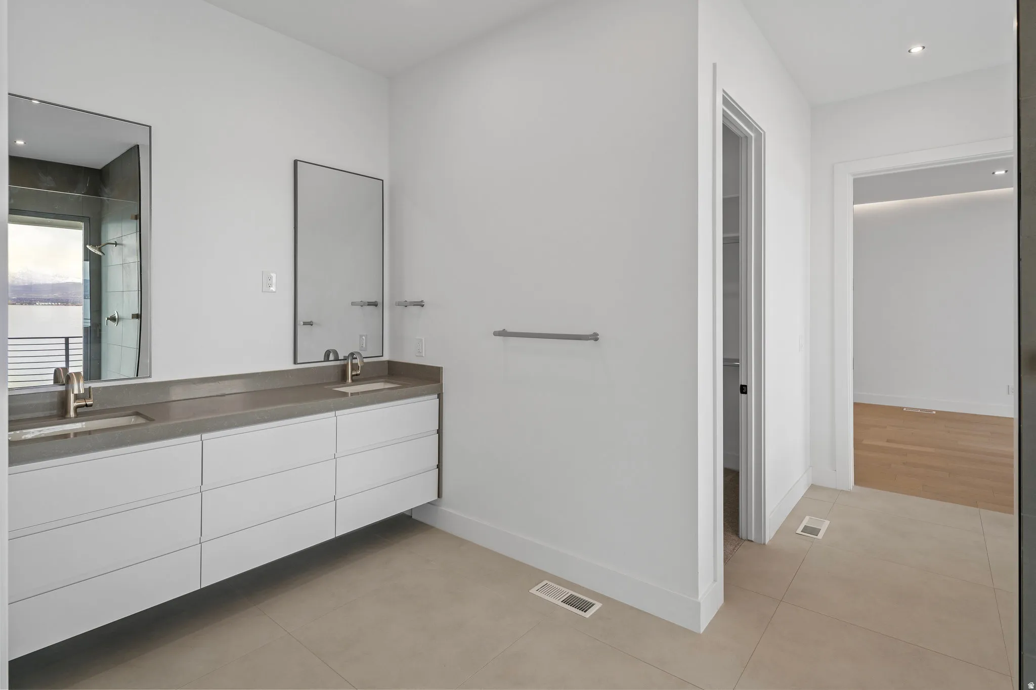 Floating dual vanity with integrated sinks, brushed nickel faucets, and a dark stone countertop