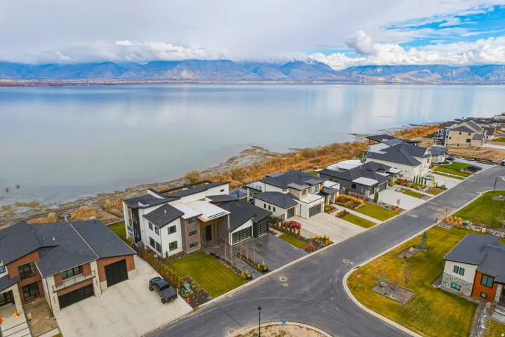Lakeside community with modern architectural styles, paved roadways, and landscaped lots