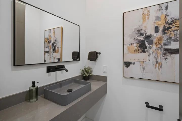 Floating vanity with a rectangular vessel sink, wall-mounted faucet, and matte black accents