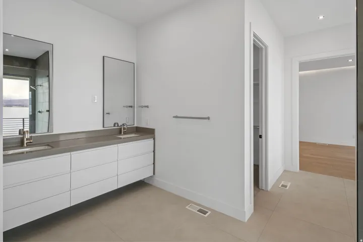 Floating dual vanity with integrated sinks, brushed nickel faucets, and a dark stone countertop