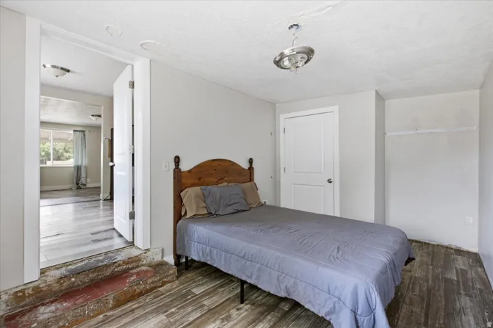 Wood-finish flooring throughout, white interior doors, and a ceiling-mounted light fixture