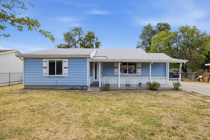 Light blue siding exterior featuring a covered front porch with white railing, white shutters, and a front entry door