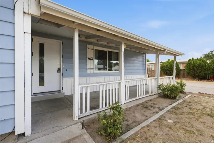 Covered front porch with white railings and blue siding