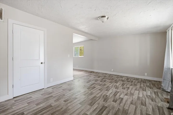 Wood-finish flooring, neutral wall tones, and overhead lighting
