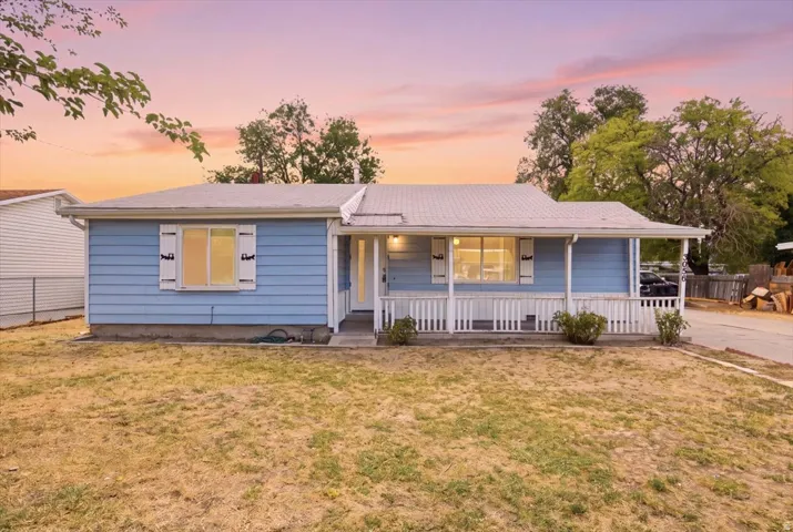 Light blue siding exterior with white window shutters and a covered front porch featuring white railing