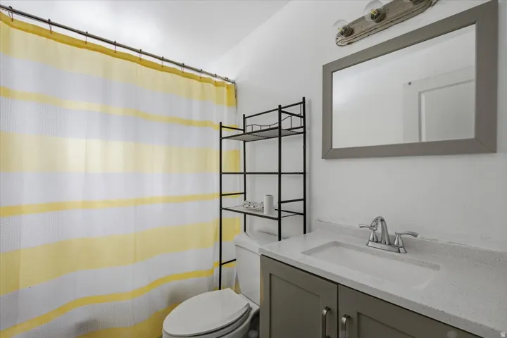Vanity with a light-colored countertop and integrated sink, framed mirror, and chrome faucet